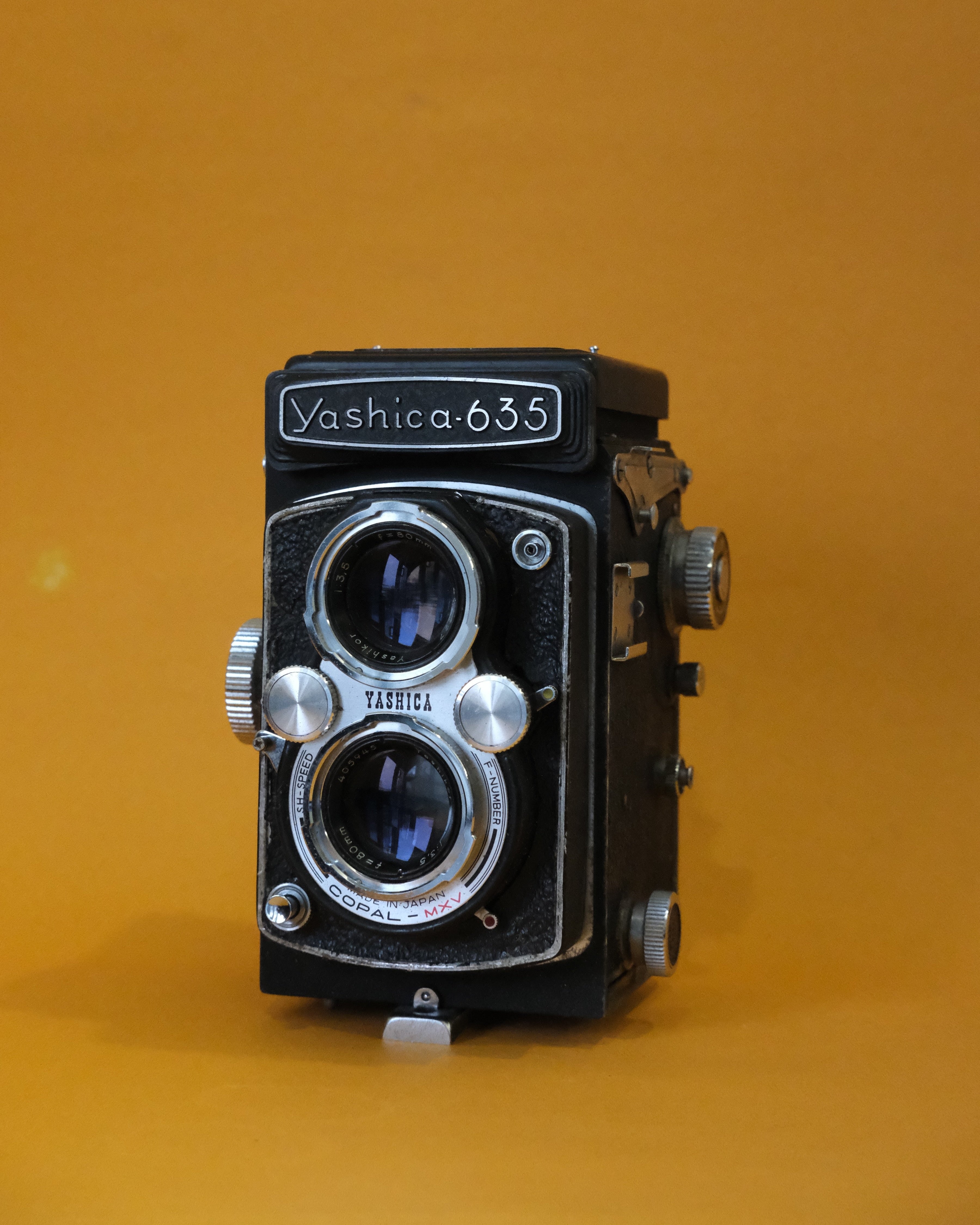 Vintage Yashica 635 camera on an orange background